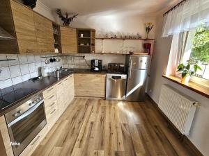 a kitchen with wooden cabinets and stainless steel appliances at Zawoja Domek 1895 - Sauna i Bania in Zawoja