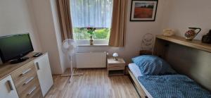 a small living room with a tv and a couch at Ferienwohnung Fellnasen WG 2 in Krefeld
