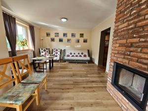 a living room with a fireplace and a brick wall at Zawoja Domek 1895 - Sauna i Bania in Zawoja