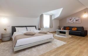 Un dormitorio con una cama grande y un sofá. en Villa Filton, en Vranje Selo