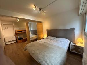 Un dormitorio con una cama grande y un espejo. en Appartement central avec Spa, en Crans-Montana 26 fotos más