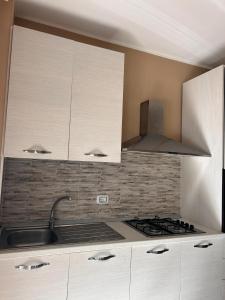 een keuken met witte kasten en een kookplaat oven bij Appartamento Centro Cagliari con ampio Terrazzo in Cagliari