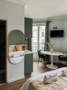 a bedroom with a large mirror and a table at Studio de charme parisien in Levallois-Perret