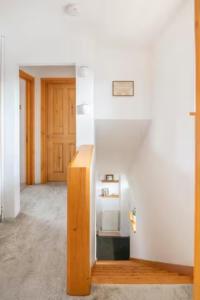a room with white walls and a wooden stair case at Bright Double Room l Smart TV l 5 Minute Walk from Train Station in Egerton