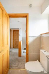 a bathroom with a white toilet and a hallway at Bright Double Room l Smart TV l 5 Minute Walk from Train Station in Egerton