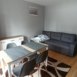 a living room with a couch and a table and chairs at Apartament Dunikowskiego 57m2 in Lublin