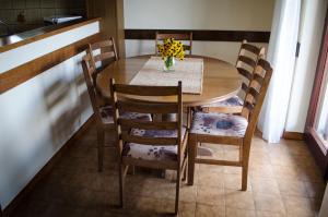 a dining room table and chairs with a vase of flowers on it at Apartment Luno in Zvoneće +44 photos