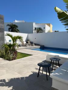 a patio with two stools and a swimming pool at Bamboo in Boca del Río