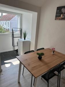 a wooden table and chairs in a room with a window at Modernes Apartment in Ruhiger Lage in nähe des Fischereihafens in Bremerhaven