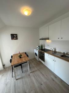 a kitchen with a wooden table in a room at Modernes Apartment in Ruhiger Lage in nähe des Fischereihafens in Bremerhaven