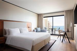 a hotel room with a bed and a view of the ocean at Riviera Marriott Hotel La Porte De Monaco in Cap d'Ail