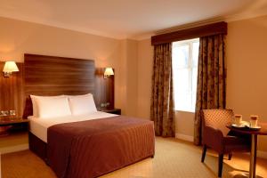 ein Hotelzimmer mit einem Bett und einem Fenster in der Unterkunft Dillon’s Hotel in Letterkenny
