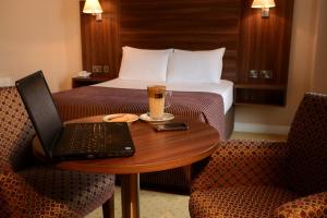 ein Hotelzimmer mit einem Laptop auf einem Tisch mit einem Bett in der Unterkunft Dillon’s Hotel in Letterkenny