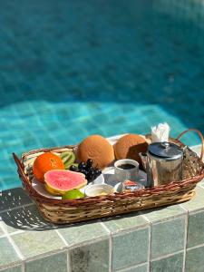 ein Obstkorb auf einem Tisch neben einem Pool in der Unterkunft Flat Sonhos de Milagres in São Miguel dos Milagres