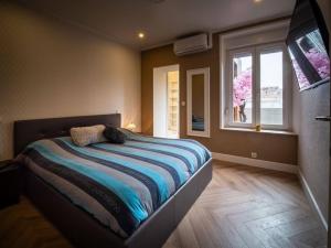 a bedroom with a bed with a television and a window at Duplex Jeanne d'Arc Billard Baby en option Escape Game Logements Insolites in Nancy