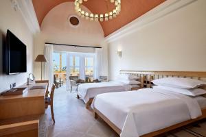 a hotel room with two beds and a chandelier at Sheraton Miramar Resort El Gouna in Hurghada
