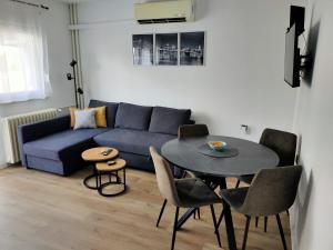 a living room with a blue couch and a table at Broadway Apartment in Požega