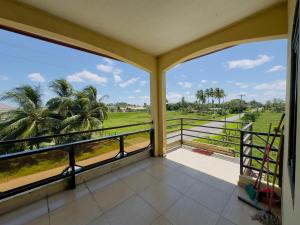 a balcony with a view of a field and palm trees at Rohansappartementen in Wanica