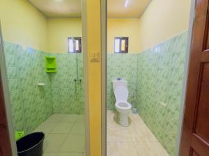 a bathroom with a toilet and a shower with green tiles at Rohansappartementen in Wanica +3 photos