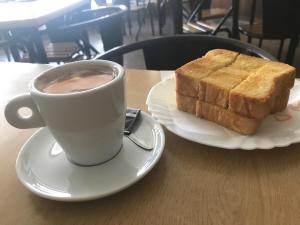 a cup of coffee and a piece of bread on a table at casa largo do cruzeiro in Peso da Régua