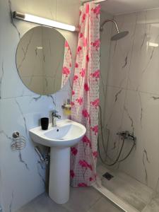 a bathroom with a sink and a shower with a mirror at Rosi Rhodos in Rhodes Town