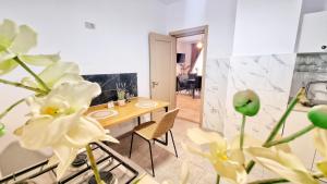a dining room with a table and some flowers at KYD VILA - Studiouri si Apartamente la 100m de Plaja Debarcader in Eforie Nord +141 photos