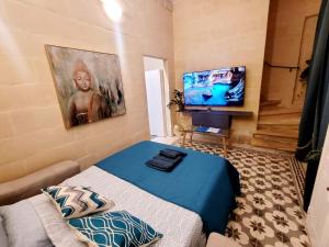 Cette petite chambre comprend un lit et une télévision à écran plat. dans l'établissement Sliema Traditional&Unique House, à Sliema