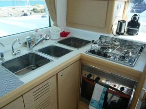 a kitchen with a sink and a stove and a window at Maol in Saint-Gilles-Croix-de-Vie