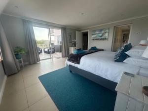 a bedroom with a large bed and a balcony at Lagoon Views at Langebaan in Langebaan