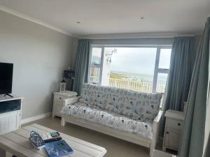 a living room with a couch and a large window at Lagoon Views at Langebaan in Langebaan