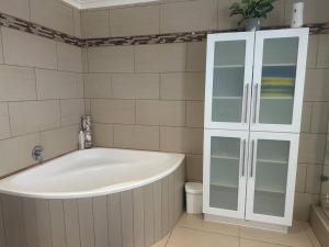 a bath tub in a bathroom with a white cabinet at Lagoon Views at Langebaan in Langebaan +46 photos