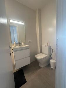 a bathroom with a toilet and a sink and a mirror at Casita Estrella in Arenal d'en Castell +11 photos