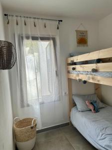 a small bedroom with a bunk bed and a window at Casita Estrella in Arenal d'en Castell