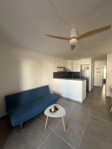 Una sala de estar con un sofá azul y una mesa. en Casita Estrella, en Arenal d'en Castell 11 fotos más