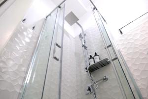 una doccia con una porta in vetro in un bagno di My Dream in Rome a Roma Altre 37 foto