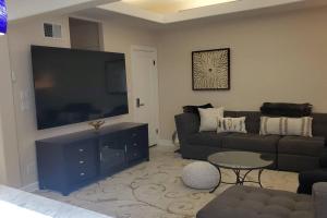 un salon avec un canapé et une grande télévision à écran plat dans l'établissement Cozy SF Home 4 Bedroom 2 Bath, à San Francisco