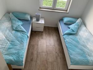 two beds in a room with blue pillows at Klimatisierte Ferienwohnung in Balingen