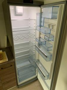 an empty refrigerator with its door open in a kitchen at Klimatisierte Ferienwohnung in Balingen