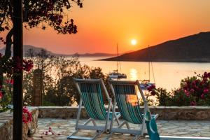 two chairs sitting on a patio watching the sunset at Villa Ftenagia in Halki