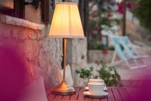 a lamp sitting on a table next to a coffee cup at Villa Ftenagia in Halki
