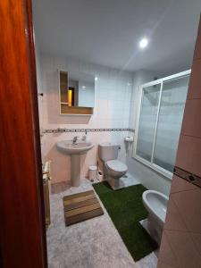 a bathroom with a sink and a toilet and a mirror at Barquiña Beach House in the heart of San Vicente in San Vicente de la Barquera +34 photos