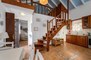 a living room with a staircase and a kitchen at Villa Ftenagia in Halki