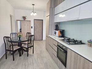 a kitchen and dining room with a table and a microwave at Apartament Andreea 15 in Mamaia Nord