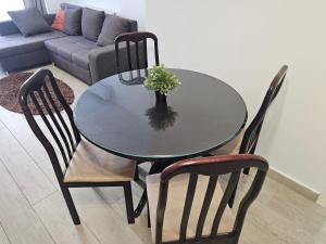 a glass table with two chairs and a vase with a plant at Apartament Andreea 15 in Mamaia Nord +3 photos
