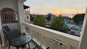 a balcony with a table and chairs and a view of a city at Alyzia Apartment in Xylokastro