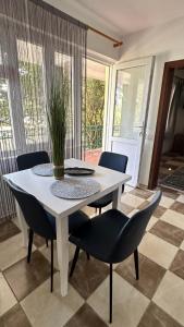 a white table with chairs and a potted plant on it at GreenHouse in Brca