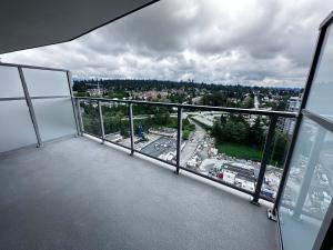 an empty balcony with a view of a city at New condo near Lougheed Mall & SFU in Coquitlam +9 photos