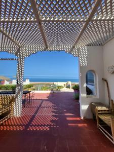 a patio with a pergola with a view of the ocean at Dar janoub in Aït Raïs Aomar