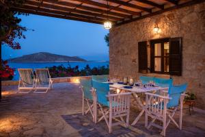 a table and chairs on a patio with a view of the ocean at Villa Ftenagia in Halki