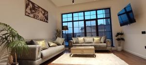 a living room with two couches and a tv at Luxury 4 bedroom villa with hot indoor swimming pool in Cǝnubi